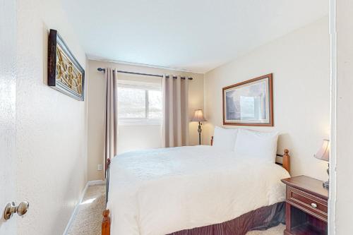 a bedroom with a white bed and a window at Vista Del Lago in Stateline