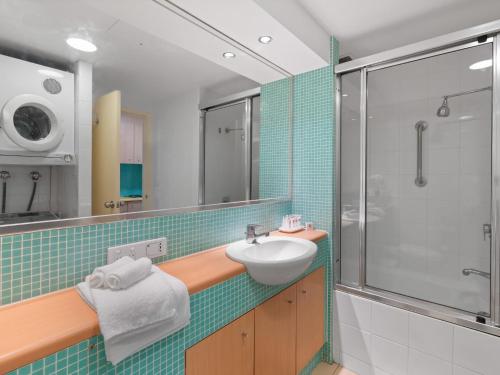 y baño con lavabo y ducha. en The Entrance Waterfront Apartment 401, en The Entrance