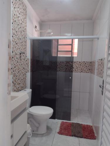 a white bathroom with a toilet and a shower at Recanto dos Passaros in Socorro