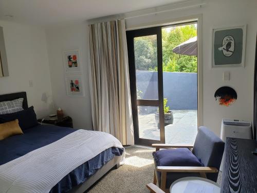 um quarto com uma cama e uma porta de vidro deslizante em A little bit of country on the city's doorstep em Napier