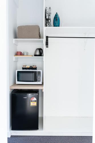 a small kitchen with a microwave and a refrigerator at Gosford Palms Motor Inn in Gosford