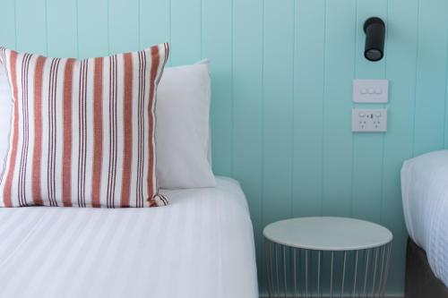 a bed with a pillow and a side table at Gosford Palms Motor Inn in Gosford
