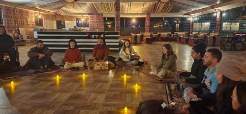 a group of people sitting on the floor with lights at Toleen Camp wadi rum in Wadi Rum