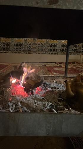 a grill with a fire in the middle of it at Toleen Camp wadi rum in Wadi Rum