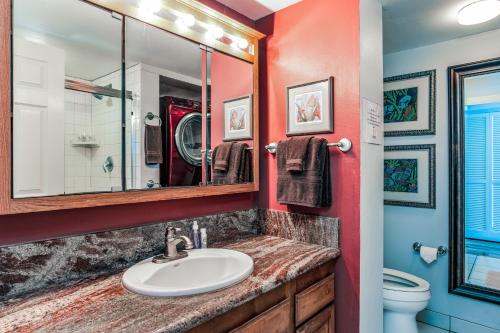 La salle de bains est pourvue d'un lavabo et d'un miroir. dans l'établissement Paradise Found at White Sands Village 105, à Kailua-Kona