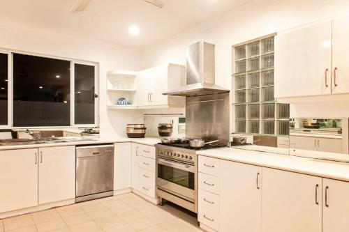 a kitchen with white cabinets and a stove top oven at Marlin House in Nadi