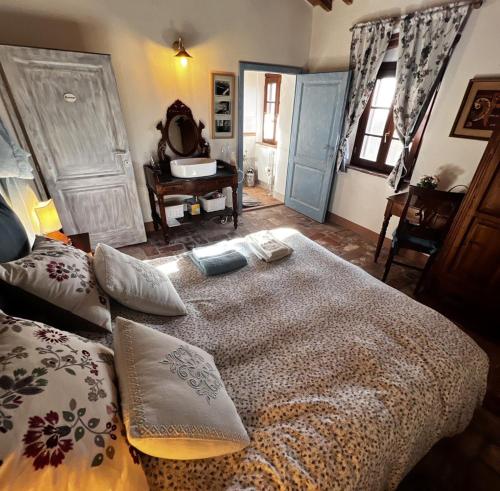 een slaapkamer met een groot bed met kussens erop bij Casale Saundarya - yoga e ayurveda in Toscana in Casciana Terme