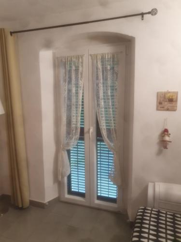a bedroom with a sliding glass door with a window at La casa di Balto, un nido per 2 in Castelnuovo Magra
