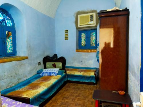um quarto com duas camas e uma tv nele em البيت النوبي em Naj‘ al Maḩaţţah