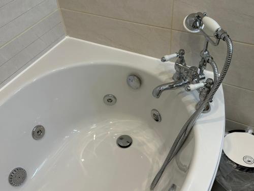 a white bath tub with a shower at Chester House Guest House in Chester