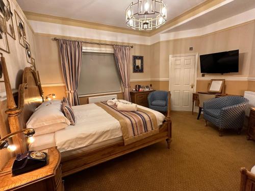 a bedroom with a bed and a desk and a television at Chester House Guest House in Chester