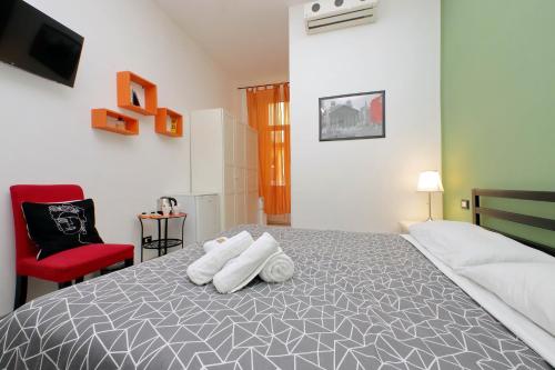 um quarto com uma cama e uma cadeira vermelha em Lucky Holiday Rooms em Roma