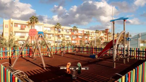 a playground with a slide and swings at Casa Guira - Fuerteventura in Parque Holandes