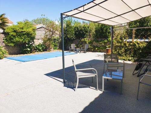 d'une terrasse avec une table et des chaises sous un auvent. dans l'établissement L Annexe - Studio avec Piscine Privee, à Les Sables-dʼOlonne