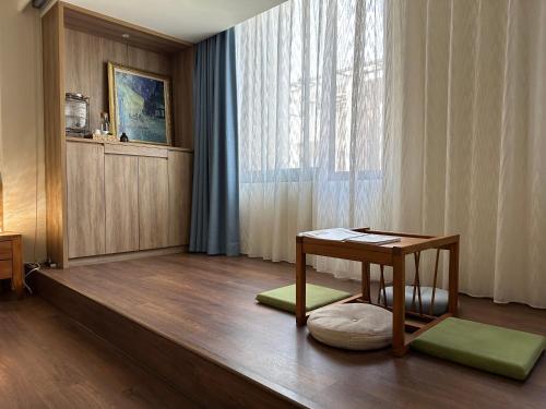 ein Wohnzimmer mit einem Tisch und einem Fenster in der Unterkunft 三木三白包棟民宿 in Puli