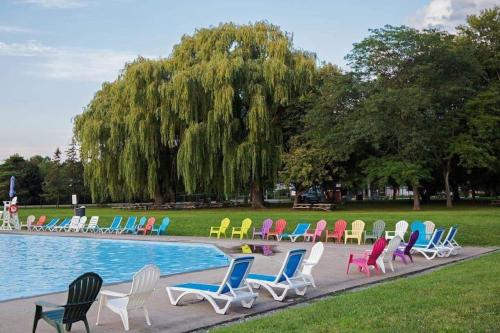 eine Gruppe von Stühlen neben einem Pool in der Unterkunft Falcon Cottages in Niagara on the Lake