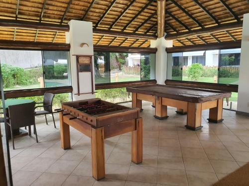 Flat TOP em Itaparica في إتاباريكا: غرفة بها طاولتين بينج بونغ ونوافذ