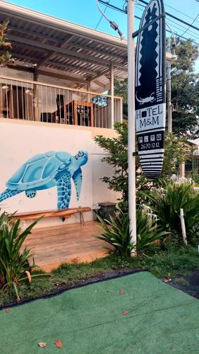 a painted turtle sitting on a bench in front of a building at Hotel M&M Beach House in Coco