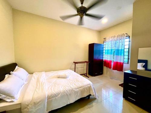 a bedroom with a bed and a ceiling fan at Homestay D Razak Wakaf Tapai in Marang