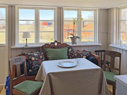a living room with a table and chairs and windows at 4 person holiday home in MARIESTAD-By Traum in Mariestad