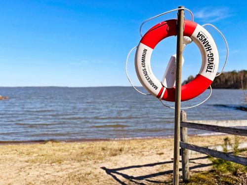 a lifebuoy on a beach with the ocean in the background at 4 person holiday home in MARIESTAD-By Traum in Mariestad