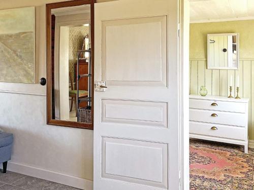 een deur in een kamer met een spiegel en een dressoir bij Holiday home MARIESTAD X in Mariestad
