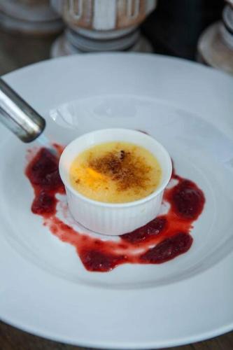 a white plate with a cup of food on a red sauce at Nusa dua Ocean View with Private Beach in Nusa Dua