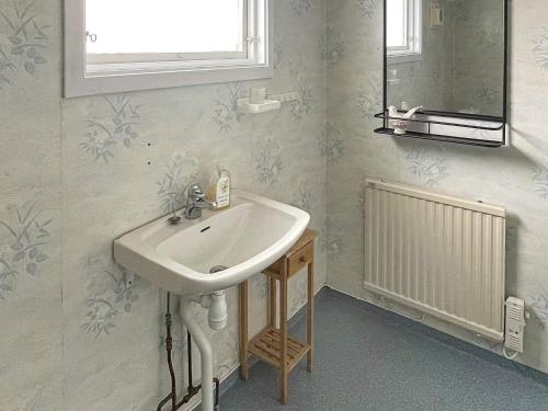 ein Bad mit einem weißen Waschbecken und einem Fenster in der Unterkunft Holiday home Ronneby VI in Ronneby