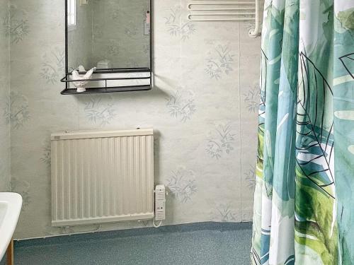a bathroom with a radiator and a mirror at 2 person holiday home in Ronneby-By Traum in Ronneby