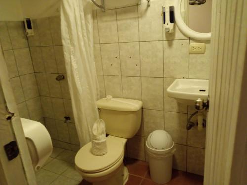 a small bathroom with a toilet and a sink at Hotel M&M Beach House in Coco