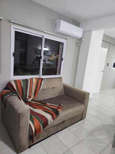 a couch sitting in a room with a window at Departamento Capital II in La Rioja