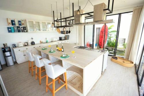 a kitchen with a large wooden table and chairs at Nusa dua Ocean View with Private Beach in Nusa Dua