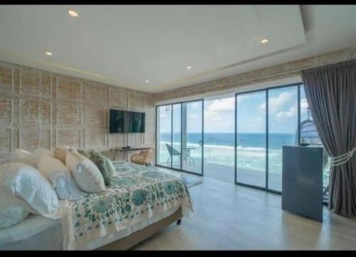 a bedroom with a bed and a view of the ocean at Nusa dua Ocean View with Private Beach in Nusa Dua