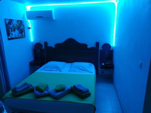 a blue room with a bed with a blue light at La Martiniquaise in Sainte-Anne