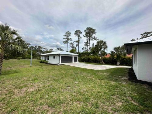 una piccola casa bianca in un campo con un cortile di 2/1 Naples Hideaway a Naples