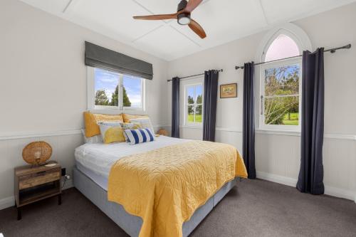 - une chambre avec un lit et un ventilateur de plafond dans l'établissement The Chapel- Kohukohu, à Kohukohu Town District