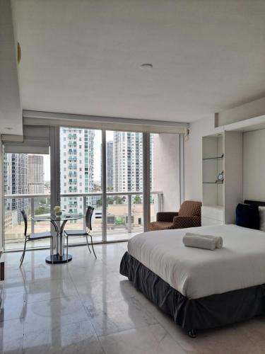 a bedroom with a large bed and a table with chairs at Icon Brickell W Residences in Miami