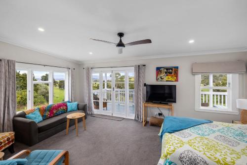 a living room with a bed and a couch at Harbour View in Kohukohu Town District