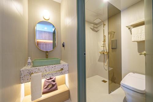bagno con lavandino, servizi igienici e specchio di H-Avenue Hotel Geomdan New Town a Incheon