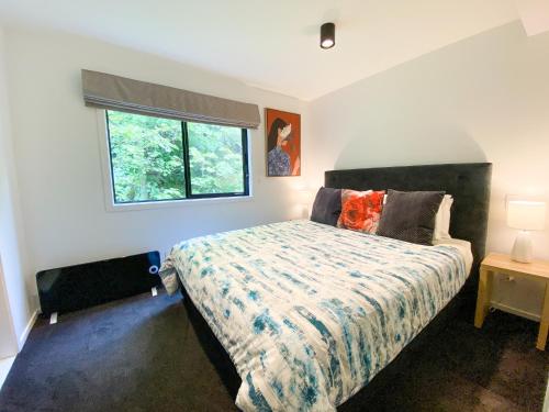 a bedroom with a bed and a window at Modern 2-bedroom Apartment 7-mins walk to Queenstown in Queenstown