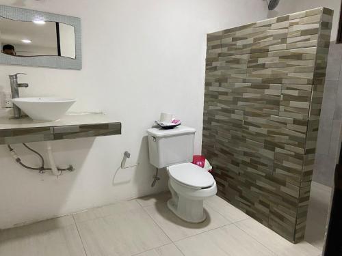 a bathroom with a toilet and a sink at Hotel Miriam Bacalar in Bacalar