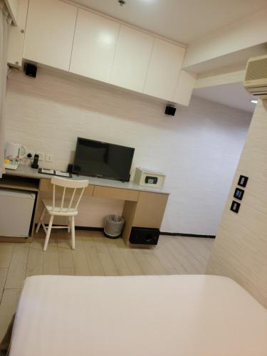 a room with a kitchen with a desk and a microwave at Mingle With The Star in Hong Kong