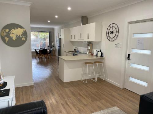 a kitchen and living room with white cabinets and a counter at Annie's Apartment in Mount Gambier