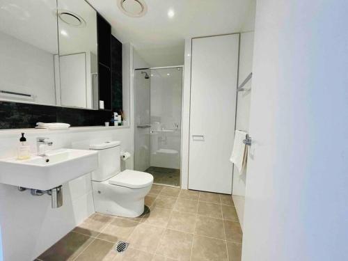 a white bathroom with a toilet and a sink at Sydney Executive Apartment 3beds2baths parking Chatswood in Sydney