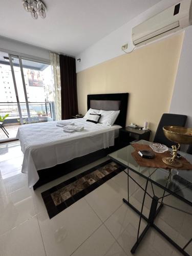 a bedroom with a bed and a table and a window at Artur in Buenos Aires