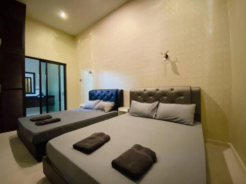 a bedroom with two beds with brown pillows on them at C02 EuroStyle Seri Alam Homestay in Masai