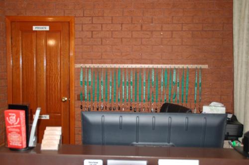 a table with a blue chair in front of a brick wall at Meramie Motor Inn in Albury