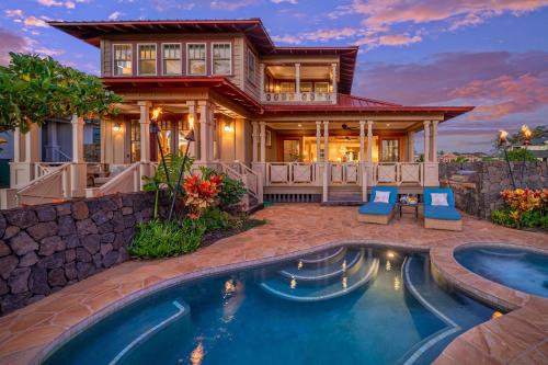 a home with a swimming pool in front of a house at Kauai Luxury Vacation Villas in Koloa