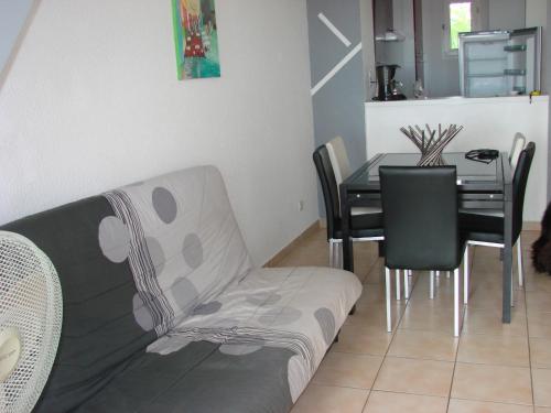 - un salon avec un canapé et une table à manger dans l'établissement LE Jasmin, à Fleury