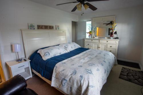 a bedroom with a bed and a ceiling fan at OceanView Oasis - Relax with Hot Tub, Breakfast, Fire Pit & Putting Green! in Panama City Beach